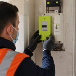 Technicien en gilet contrôlant un compteur électrique